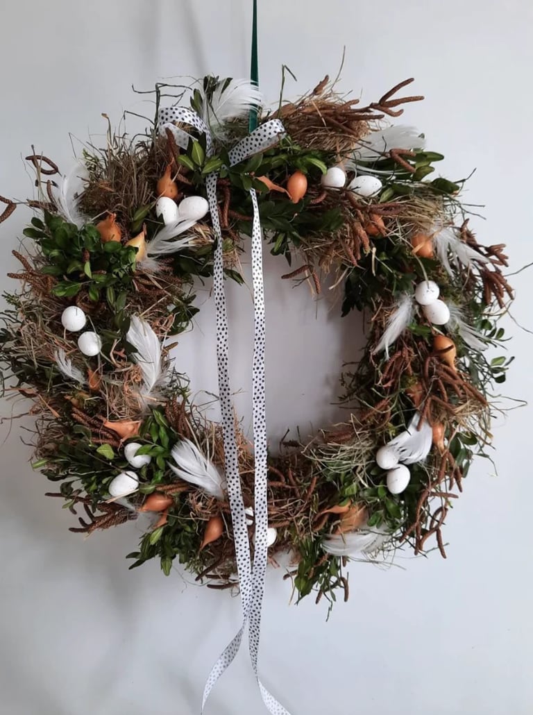 Decorative autumn wreath with dried branches, white berries, orange gourds, green foliage, and polka-dotted ribbon bow